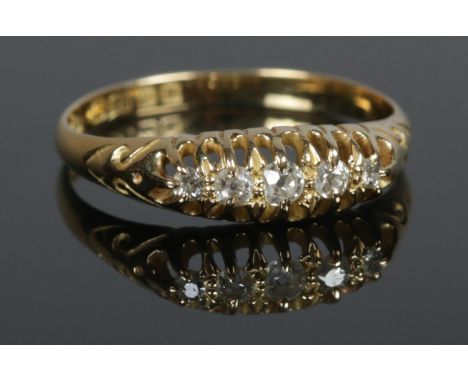 An 18ct Gold and five stone Diamond ring, with pierced bridge. Largest diamond 1/16ct. Size R. Total weight: 2.59g  