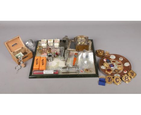 A tray of collectables. To include an assortment of Masonic lodge badges, wooden money box with a one pound note and coins, a