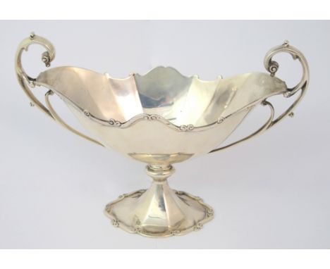 A silver bowl by R & W Sorley, Glasgow 1918, of boat shape with scalloped edge and twin looping handles on knopped pedestal b