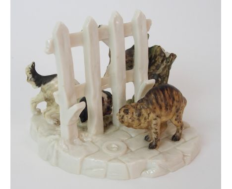 A Royal Worcester figural menu holder depicting a dog and cat engaging between fence posts, Royal Worcester moulded mark to u