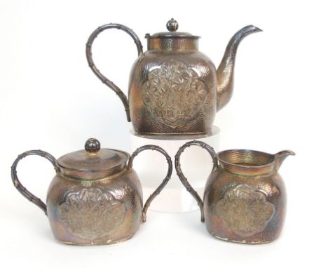 A Chinese silver three piece tea service cast with ogival panels of bamboo comprising; teapot, two handled sugar bowl and cov