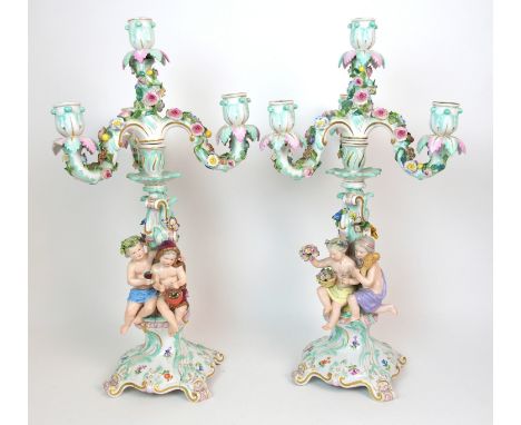 A pair of Meissen porcelain four-light candelabra 20th Century, each decorated with cherubs holding attributes of wine and ha