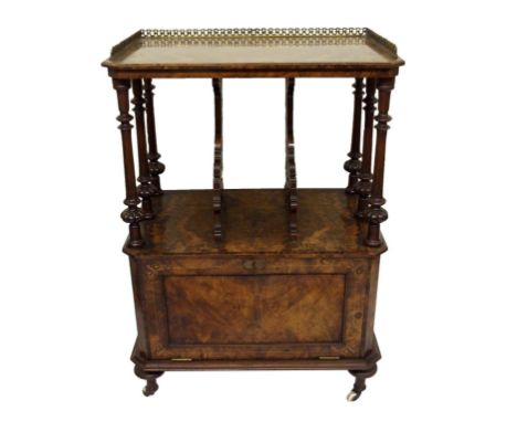 A Victorian walnut Canterbury with three quarter brass gallery above pierced dividing brackets above a hinged door and on cer