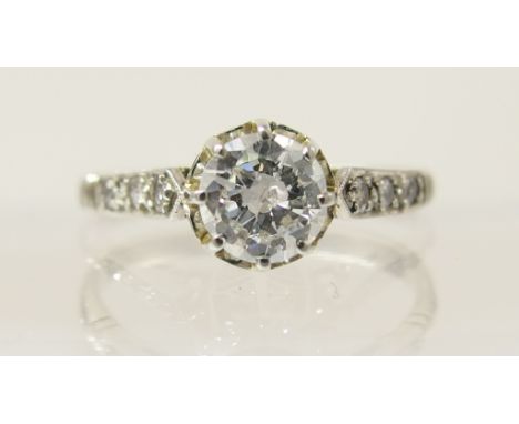 A solitaire diamond ring of approx 0.50cts claw set in decorative fine white metal setting, with further diamonds set to the 