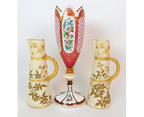 A pair of Royal Worcester porcelain ewers with a cranberry glass and enamelled footed vase ewers of tapering cylindrical-form