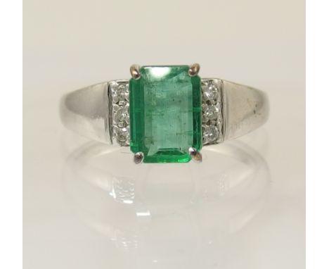 A Columbian emerald and diamond ring set with a step cut emerald of approx 1.16cts with the shoulders set with three diamonds