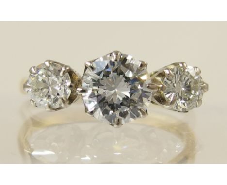 An 18ct three stone diamond ring the central diamond is approximately 0.85cts and flanked by two of approx 0.25cts, taking th