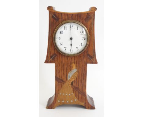An Arts and Crafts oak mantle clock circa 1900, vertical rectangular case, scroll crest above shaped face with round dial and