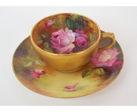 A Royal Worcester painted porcelain cabinet cup and saucer cup with gilt exterior and painted roses to interior, matching sau