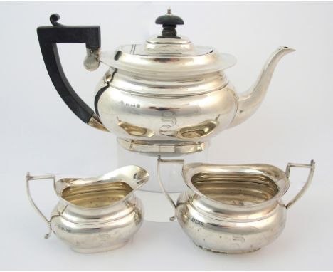 A bachelor's three piece silver tea service by Kimberley & Hewett Limited, Birmingham 1927, of plain bombe shape with curved 