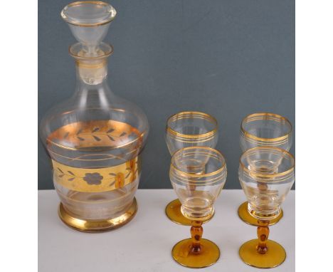 A early 20th Century glass decanter and stopper, with cut gilt band decoration, together with four matching sherry glasses wi