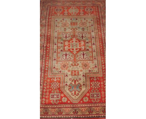 An orange ground Kazak style carpet with geometric mirab 89x155cm