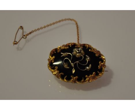A Victorian black enamel seed pearl and yellow metal mourning brooch
