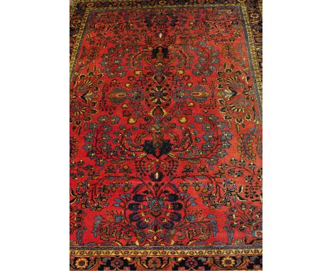 A Persian Mahal brick red ground carpet with scattered floral field within a wide triple border, 350 x 270cm