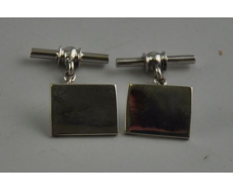 A pair of silver oblong cufflinks with chain and bar