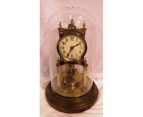 Brass anniversary clock with enamel face, in a glass dome, not working at lotting. P&amp;P Group 2 (£18+VAT for the first lot