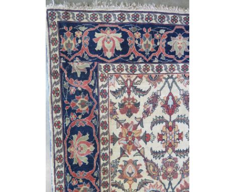 A fine hand knotted woollen Eastern rug with stylised foliate decoration on all ivory field - 204cm x 126cm - some wear, patc