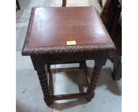 An oak carved occasional table on bobbin turned legs