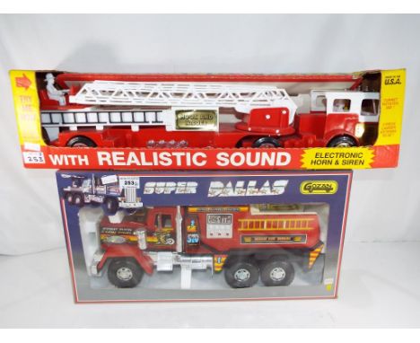 A Super Dallas Fire Department rescue truck by Gozan, model No. 817 and a further rescue truck with hook and ladder, electric
