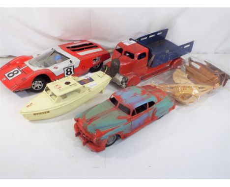 Four tin-plate vehicles and two wooden ships, comprising a tin-plate tip lorry, an American lead sled, a Ferrari 512S and a S