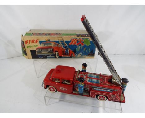 A vintage tin-plate friction operated Fire Truck with siren # MF718 in original box with packing piece