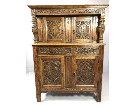 Court cupboard with two drawers and four cupboards in heavily carved American oak by furniture maker Flint and Horner Company