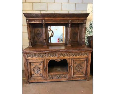 Impressive Oak Court Cupboard with intricately carved detailing, the recessed section having central bevel-edged mirror, the 