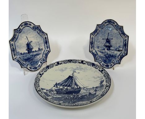 A trio of Delft wall hanging decorative plates, a pair depicting a Holland windmill scene and the other with a transfer print