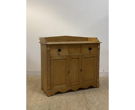 A Victorian pine side cabinet, the galleried top over three drawers and two cupboards flanked by bobbin turned split pilaster