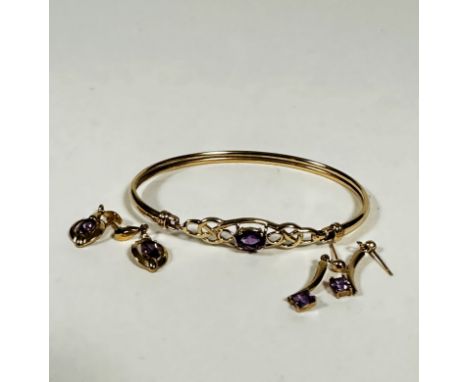 A 9ct gold stiff hinged bangle set oval amethyst in open work setting, (6.5cm x 5cm) and two pairs of 9ct gold drop earrings,