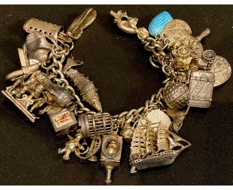 A silver charm bracelet and assorted charms, including birdcage, enamelled blue heart, imp, galleon, motor car, gold bag and 