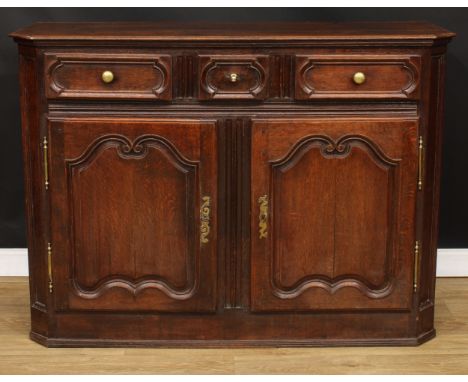 A 19th century French oak enfilade or buffet serving sideboard, slightly oversailing top with canted foreangles above three f