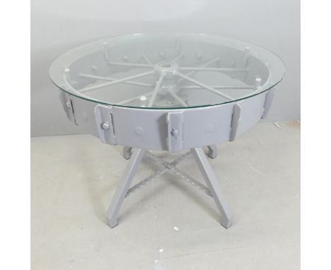 A contemporary circular glass topped table, on painted tractor wheel base. 95x76cm 