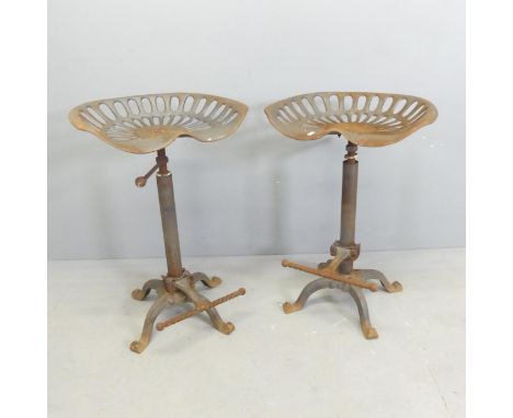 A pair of cast iron tractor seat bar stools with height adjustable seats and footrests.Good but clearly used overall conditio