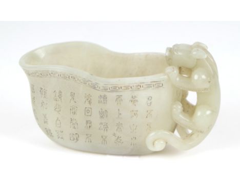 A late Chinese Republic jade vessel decorated with calligraphy and having a carved dragon handle, 13cm wide. 