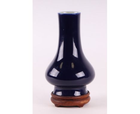 A Chinese monochrome blue glaze vase with blue seal mark to the underside, on a hardwood stand, 22cm high. 