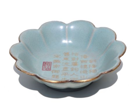 A Chinese celadon glaze petal form dish with gilt calligraphy and red seal mark to the dish centre, 18cm diameter.