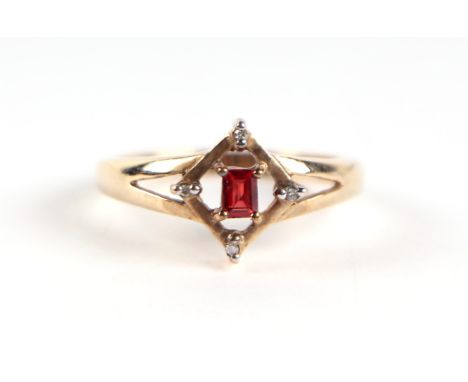 A 9ct gold red stone and diamond ring, the central emerald cut red stone flanked by four small diamonds, approx UK size 'N', 