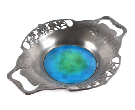 An Archibald Knox for Liberty Tudric Pewter twin-handled dish with pierced shamrock borders and central blue enamelled rounde