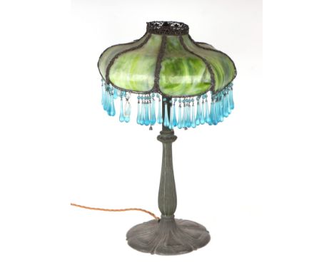 A table lamp, the metal base with moulded flutes and a mottled green glass shade with suspended turquoise drops, 58cms high. 