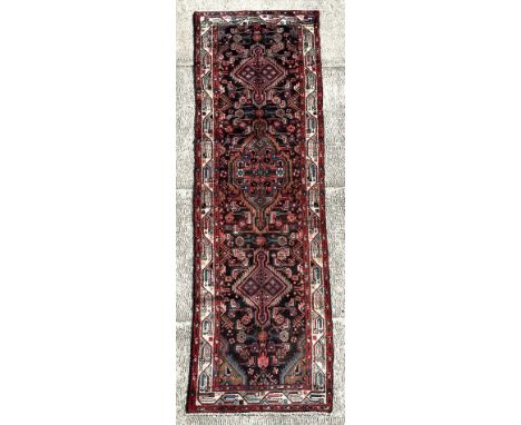 A Persian Hamadan runner on a red ground, 280 by 80cms (333).
