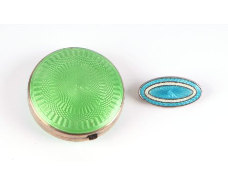 An early 20th century silver and guilloche enamel powder compact, 4cm dia; together with a blue guilloche enamel brooch (2).C