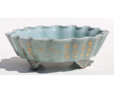 A Chinese pale celadon glaze oval footed planter with wavy rim, gilt decoration and calligraphy, 21cms wide.