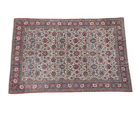 Ghom Carpet Central Iran, circa 1930  The ivory field with an all over design of flower heads and vines enclosed by blood red