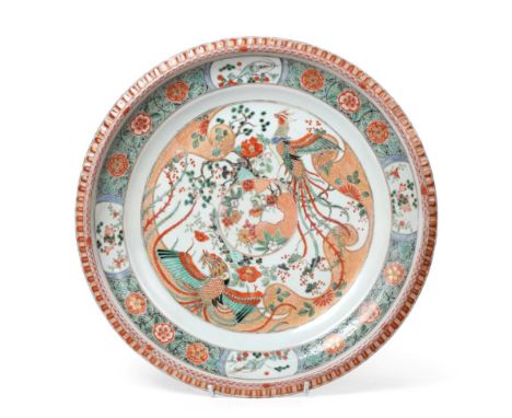 A Chinese Porcelain Charger, Kangxi, painted in famille verte enamels with a phoenix amongst foliage within a panelled border