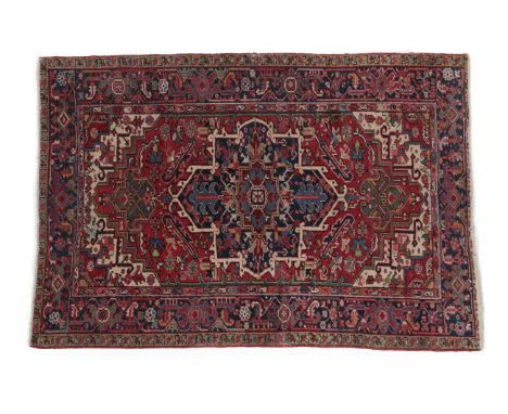 Heriz Rug North West Iran, circa 1920 The blood red field of stylised flowers and leaves around an indigo medallion framed by