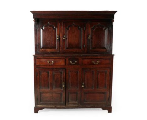 An 18th Century Joined Oak Cwpwrdd Deuddarn, Caernarfonshire, the moulded cornice above inverted turned finials and three mou