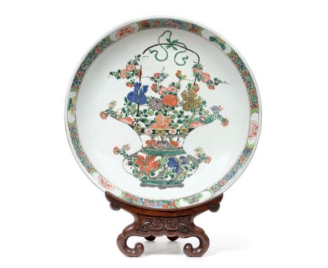 A Chinese Porcelain Dish, Kangxi, painted in famille verte enamels with a basket of flowers within a panelled border of insec