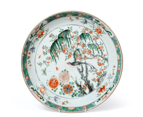 A Chinese Porcelain Charger, Kangxi, painted in famille verte enamels with a bird perched in a tree within foliate borders 39