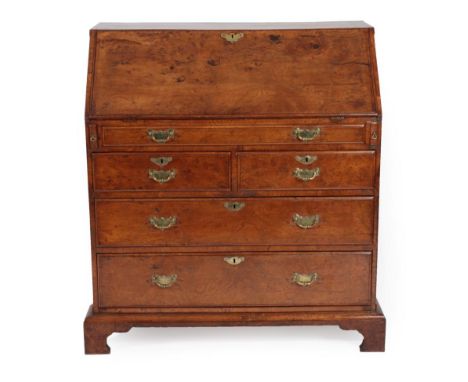 A George III Burr Elm Bureau, 2nd half 18th century, the fall enclosing a fitted interior of pigeon holes and removeable cent